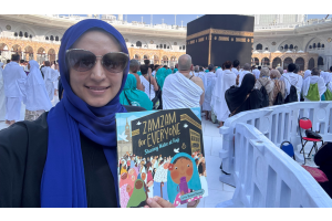 Author Razeena Omar Gutta holding up her book, Zamzam for Everyone