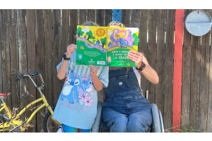 Author Ryan Rae Harbuck and child holding up their picture book, When I Grow Up I Want to Be a Chair