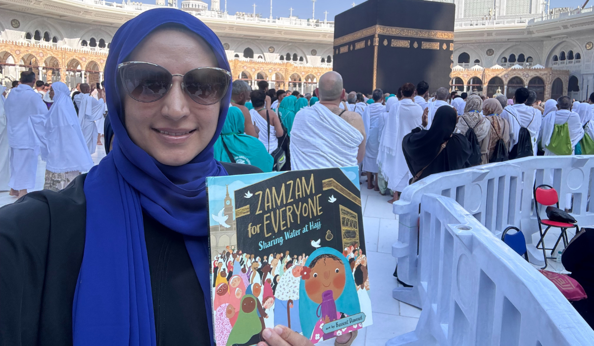 Author Razeena Omar Gutta holding up her book, Zamzam for Everyone