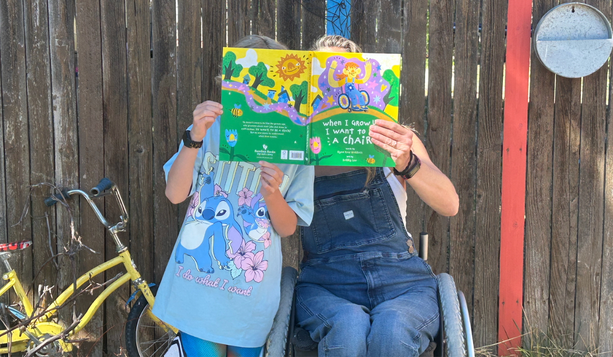 Author Ryan Rae Harbuck and child holding up their picture book, When I Grow Up I Want to Be a Chair