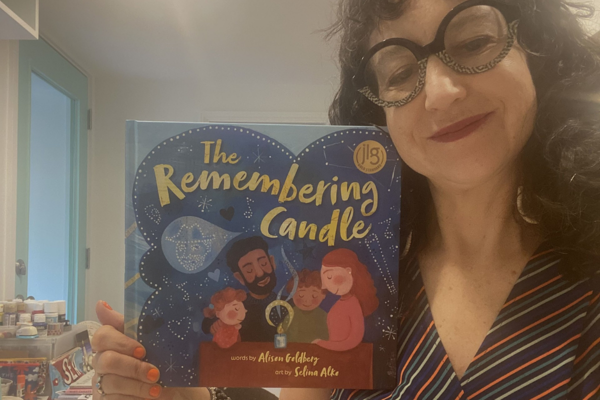 Illustrator holding up her book: "The Remembering Candle"